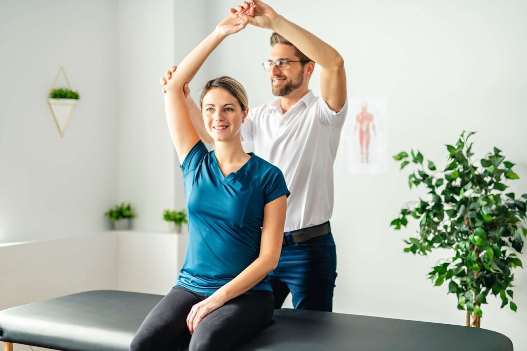 chiropractor raising the hand of a woman